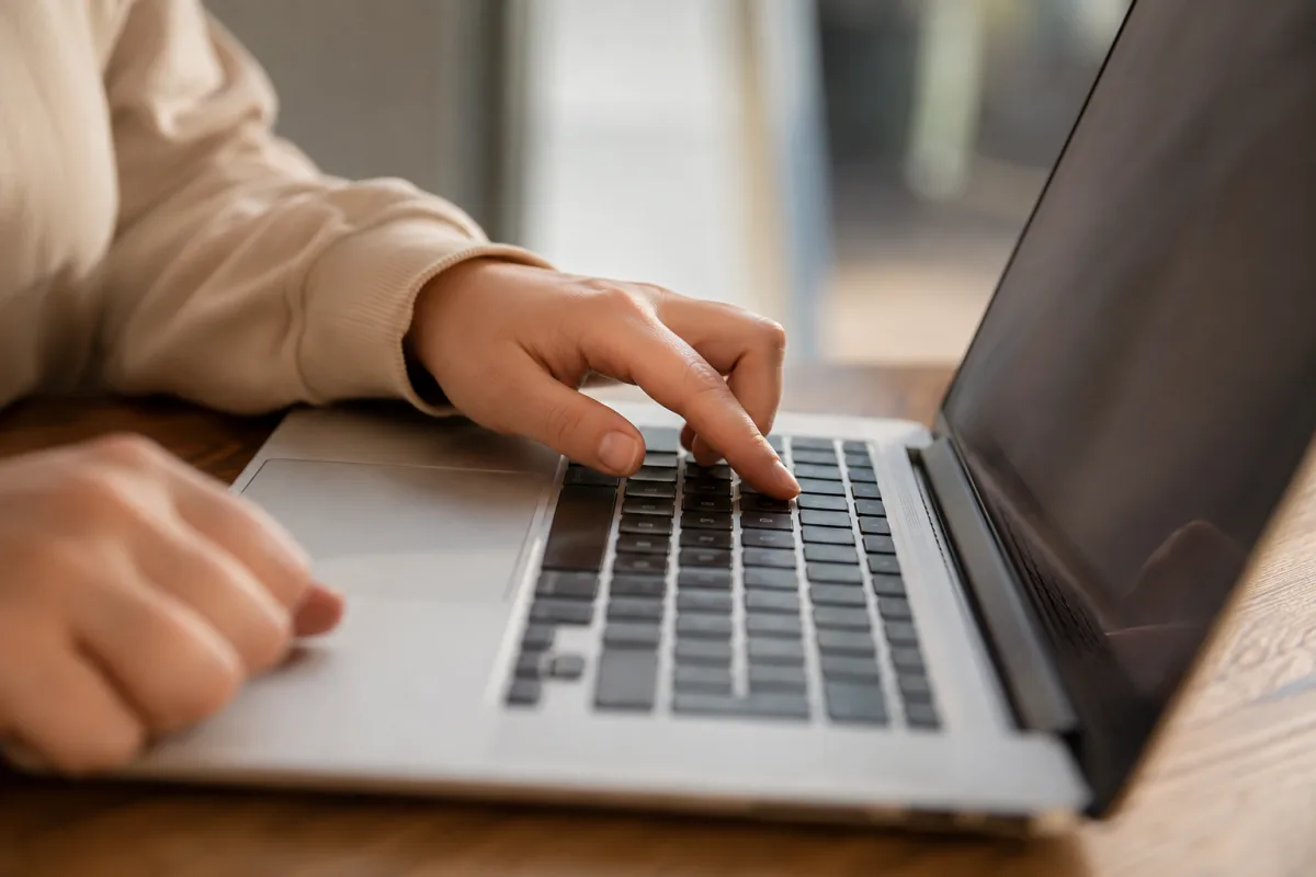 Mains sur un clavier en train de saisir des identifiants sur une page de connexion s&eacute;curis&eacute;e